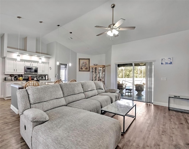 living room with ceiling fan, high vaulted ceiling, and light hardwood / wood-style floors