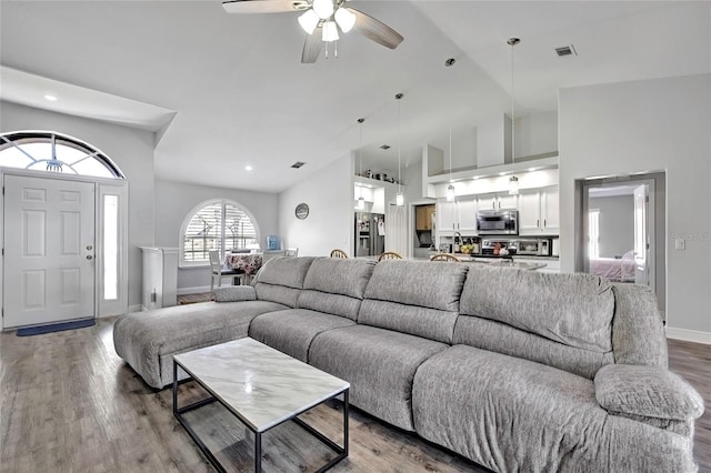 living room featuring ceiling fan, light hardwood / wood-style flooring, and high vaulted ceiling