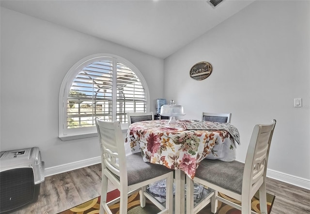 dining space featuring hardwood / wood-style flooring and lofted ceiling