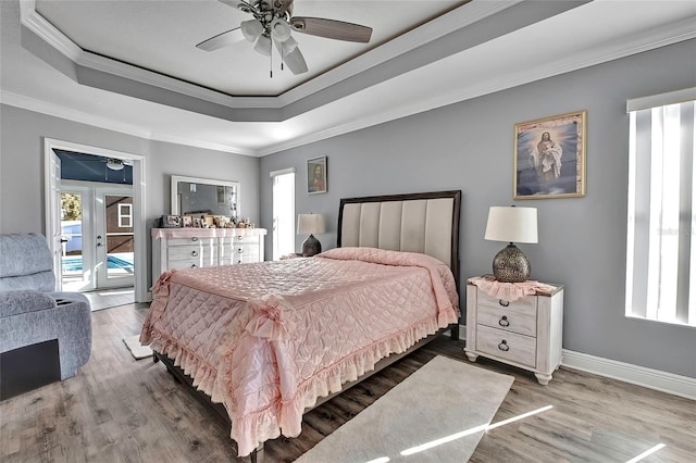 bedroom with access to exterior, ceiling fan, french doors, crown molding, and a tray ceiling