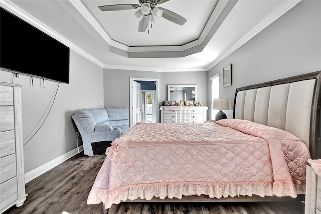 bedroom with ceiling fan, ornamental molding, dark wood-type flooring, and a tray ceiling