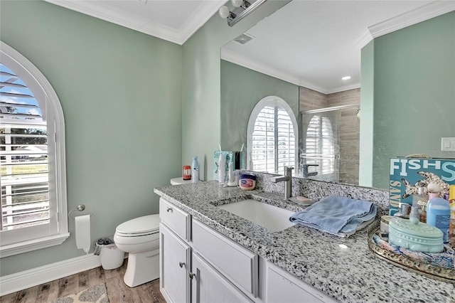 bathroom with walk in shower, crown molding, toilet, vanity, and hardwood / wood-style flooring