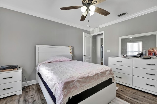 bedroom with dark hardwood / wood-style floors, ceiling fan, and ornamental molding