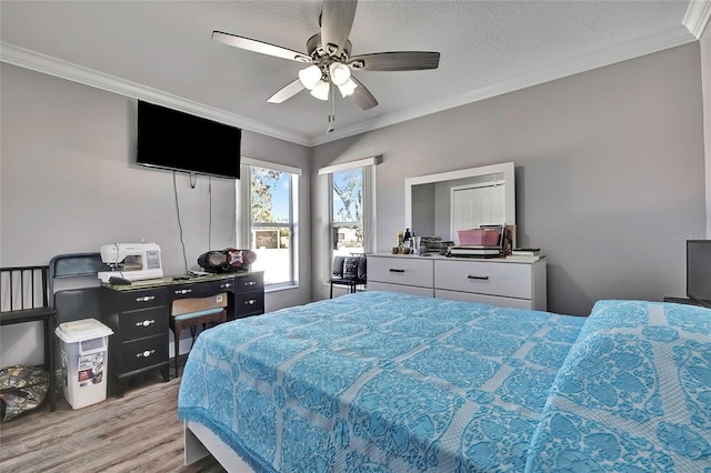 bedroom featuring ceiling fan, light wood-type flooring, ornamental molding, and a textured ceiling