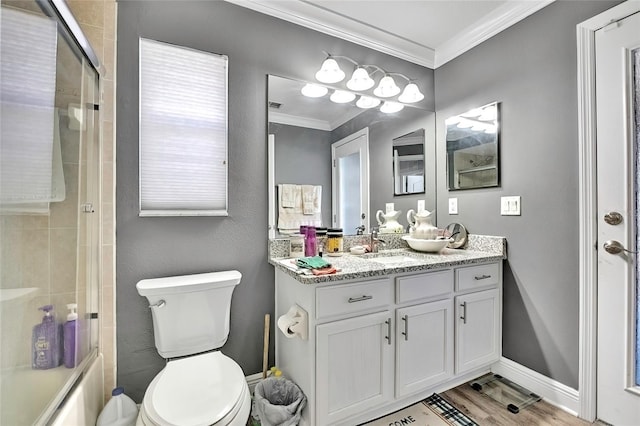 bathroom with crown molding, wood-type flooring, toilet, vanity, and a shower with shower door