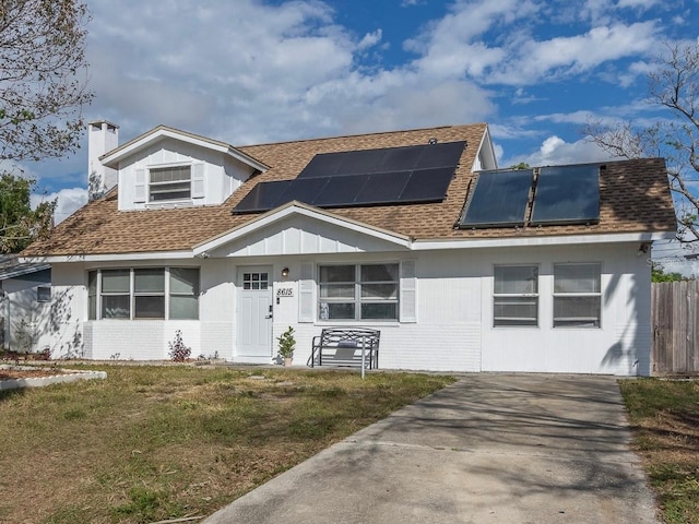 view of front of house featuring solar panels and a front yard