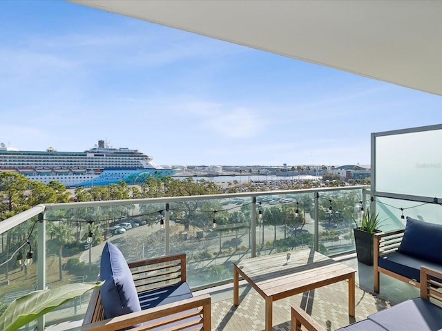 balcony with an outdoor living space and a water view