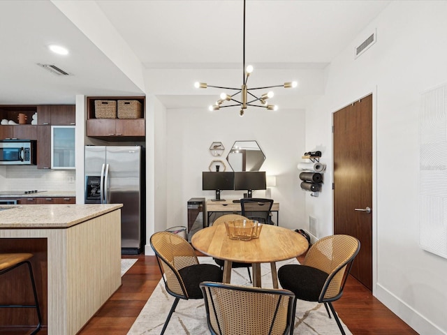 dining space featuring a notable chandelier and dark hardwood / wood-style flooring