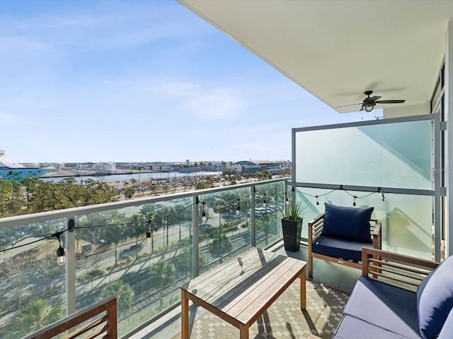 balcony with ceiling fan and a water view