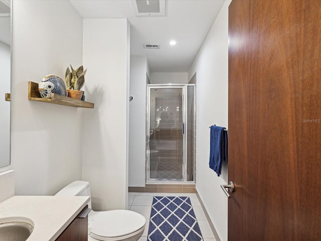 bathroom with vanity, toilet, tile patterned floors, and a shower with shower door