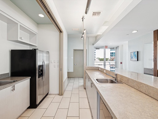 kitchen with sink, stainless steel fridge with ice dispenser, and light tile patterned floors