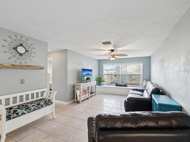 living room featuring ceiling fan, a textured ceiling, and light tile patterned floors