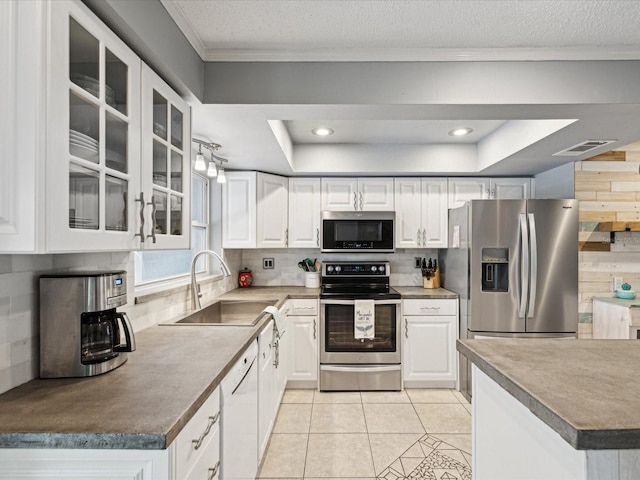 kitchen featuring sink, white cabinets, a raised ceiling, and appliances with stainless steel finishes