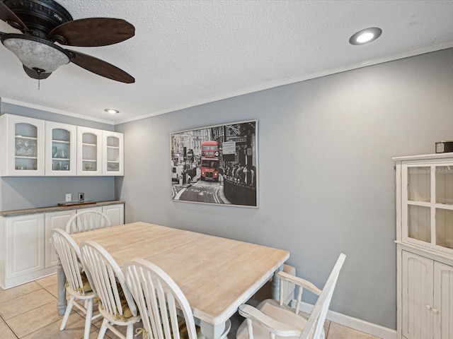 dining area featuring ceiling fan, ornamental molding, and light tile patterned flooring