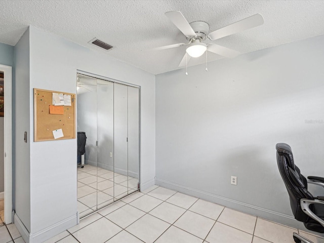 unfurnished office with ceiling fan, a textured ceiling, and light tile patterned flooring