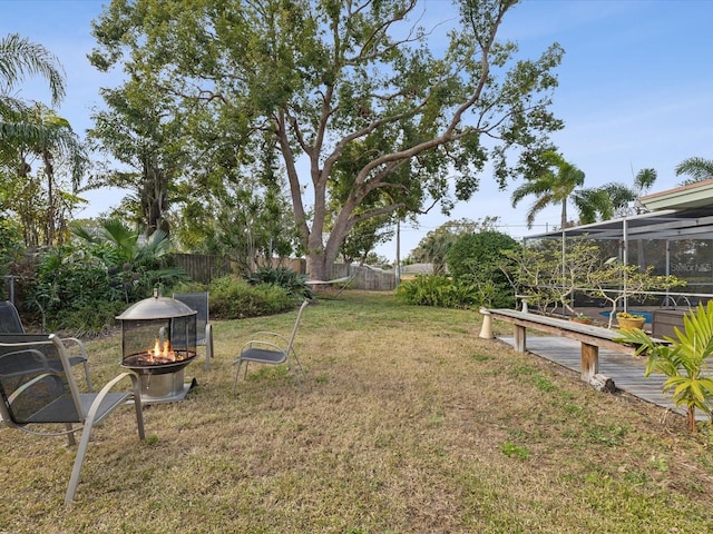 view of yard featuring an outdoor fire pit, a lanai, and a wooden deck