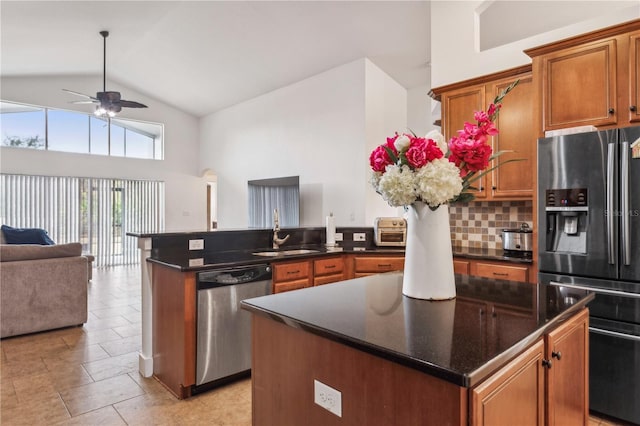 kitchen featuring decorative backsplash, a center island, sink, and appliances with stainless steel finishes