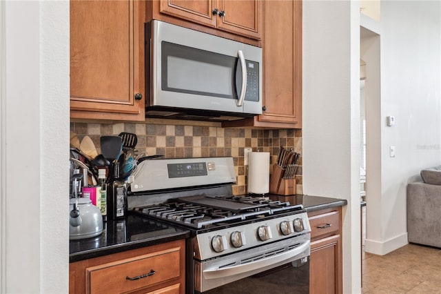 kitchen featuring decorative backsplash, light tile patterned floors, and stainless steel appliances