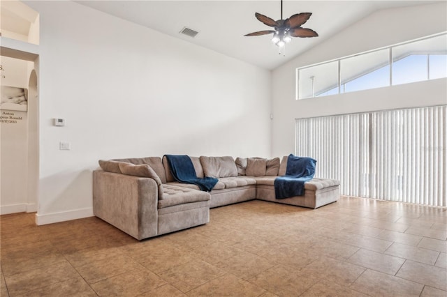 tiled living room with ceiling fan and vaulted ceiling