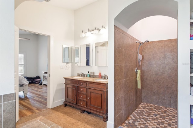 bathroom with a tile shower, vanity, and tile patterned floors