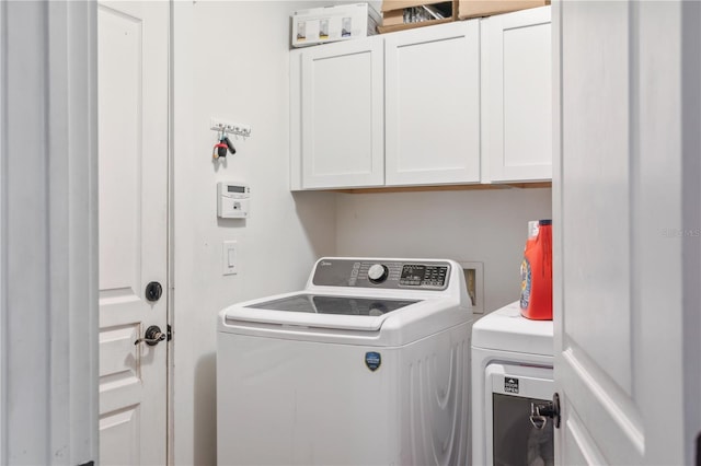 laundry room with cabinets and washing machine and clothes dryer