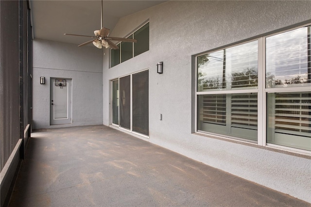 unfurnished sunroom featuring ceiling fan