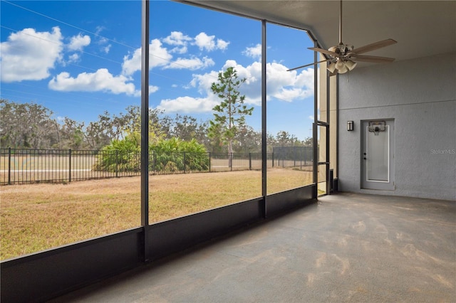 unfurnished sunroom featuring ceiling fan