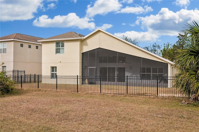 back of property with a sunroom and a yard