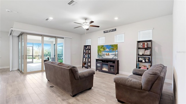 living room with light hardwood / wood-style flooring and ceiling fan