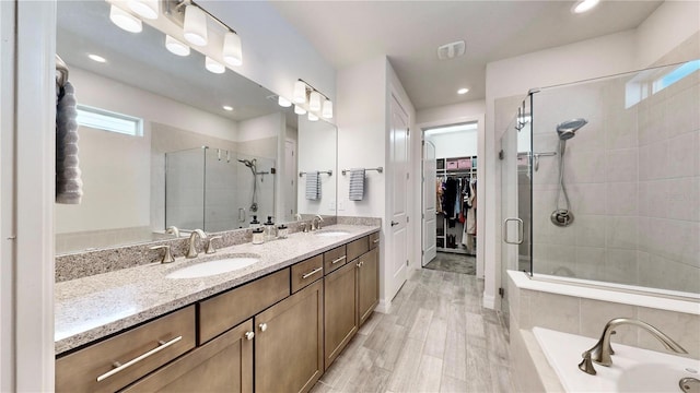 bathroom featuring vanity, independent shower and bath, and wood-type flooring