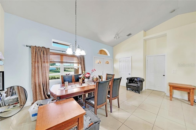 dining space featuring an inviting chandelier, lofted ceiling, and light tile patterned flooring