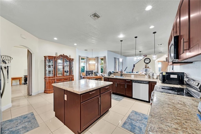 kitchen with sink, a center island, kitchen peninsula, decorative light fixtures, and appliances with stainless steel finishes