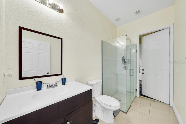 bathroom featuring tile patterned floors, walk in shower, vanity, and toilet