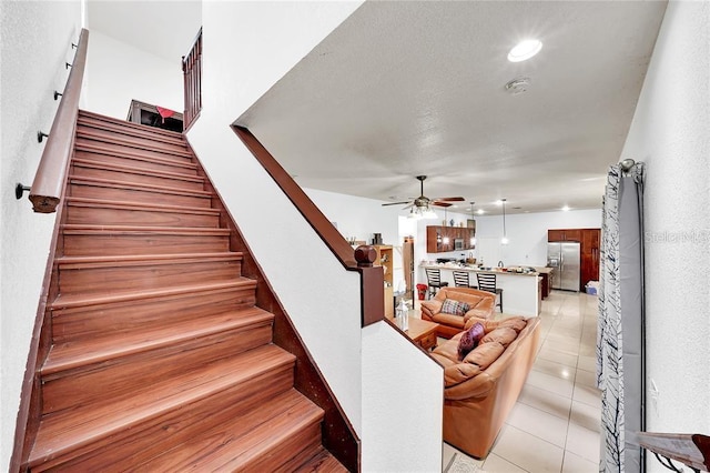 stairs with tile patterned flooring and ceiling fan