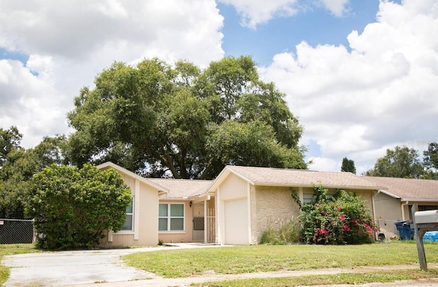 ranch-style house featuring a garage and a front lawn