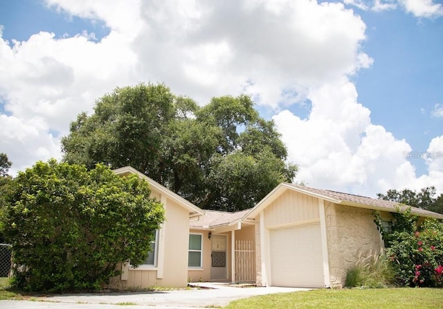 single story home featuring a garage and a front lawn