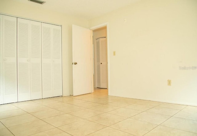 unfurnished bedroom with a closet and light tile patterned floors