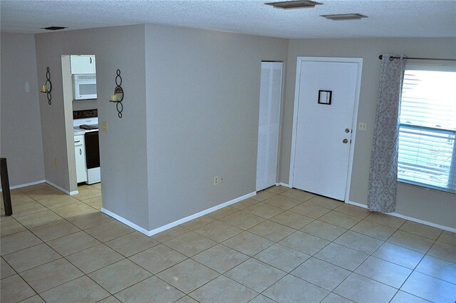 entrance foyer featuring light tile patterned flooring and a textured ceiling