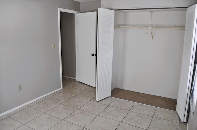 unfurnished bedroom featuring a closet and light tile patterned floors