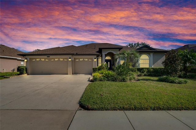 view of front of home with a yard and a garage