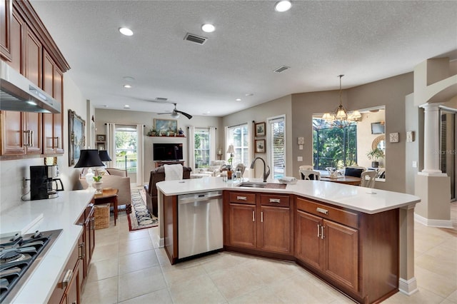 kitchen with ceiling fan with notable chandelier, sink, a textured ceiling, appliances with stainless steel finishes, and decorative light fixtures