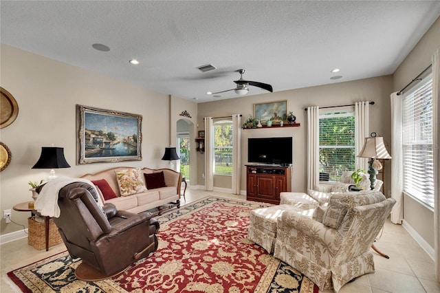 tiled living room with a textured ceiling and ceiling fan