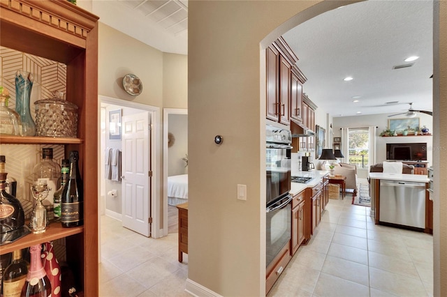 kitchen with light tile patterned floors, stainless steel appliances, and ceiling fan