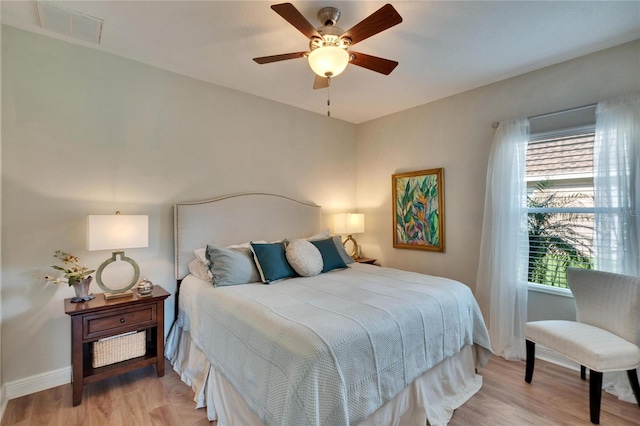 bedroom with multiple windows, light hardwood / wood-style flooring, and ceiling fan