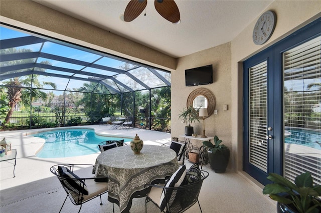 view of pool featuring ceiling fan, a patio area, and a lanai