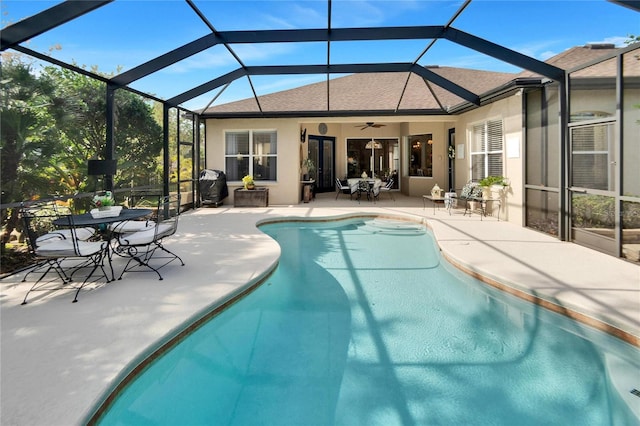 view of swimming pool featuring a patio, glass enclosure, area for grilling, and ceiling fan