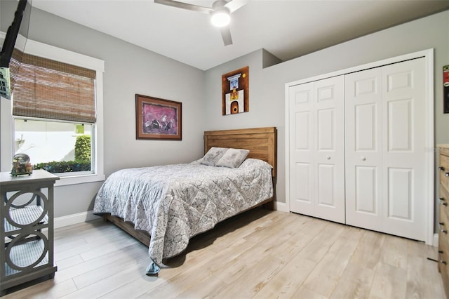 bedroom with ceiling fan, a closet, and light hardwood / wood-style floors