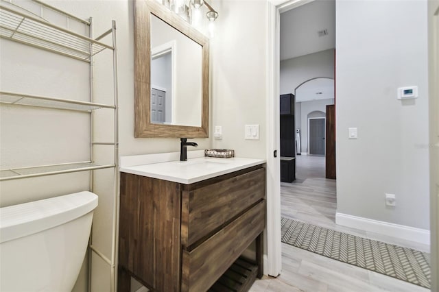 bathroom with hardwood / wood-style floors, vanity, and toilet