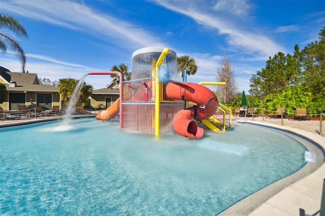 view of swimming pool featuring a playground