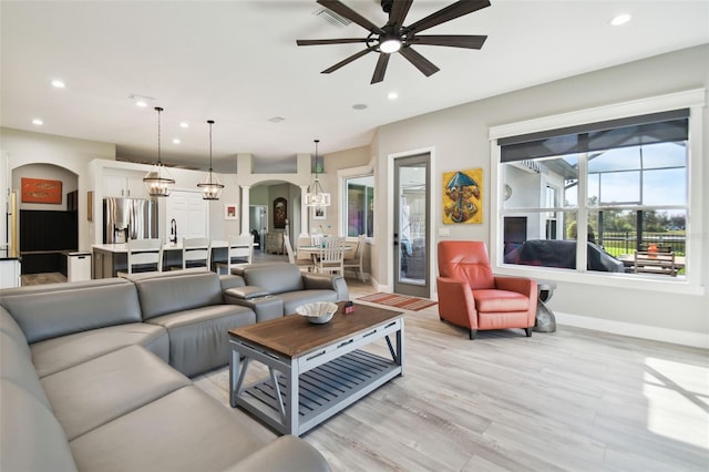 living room with ceiling fan and light wood-type flooring